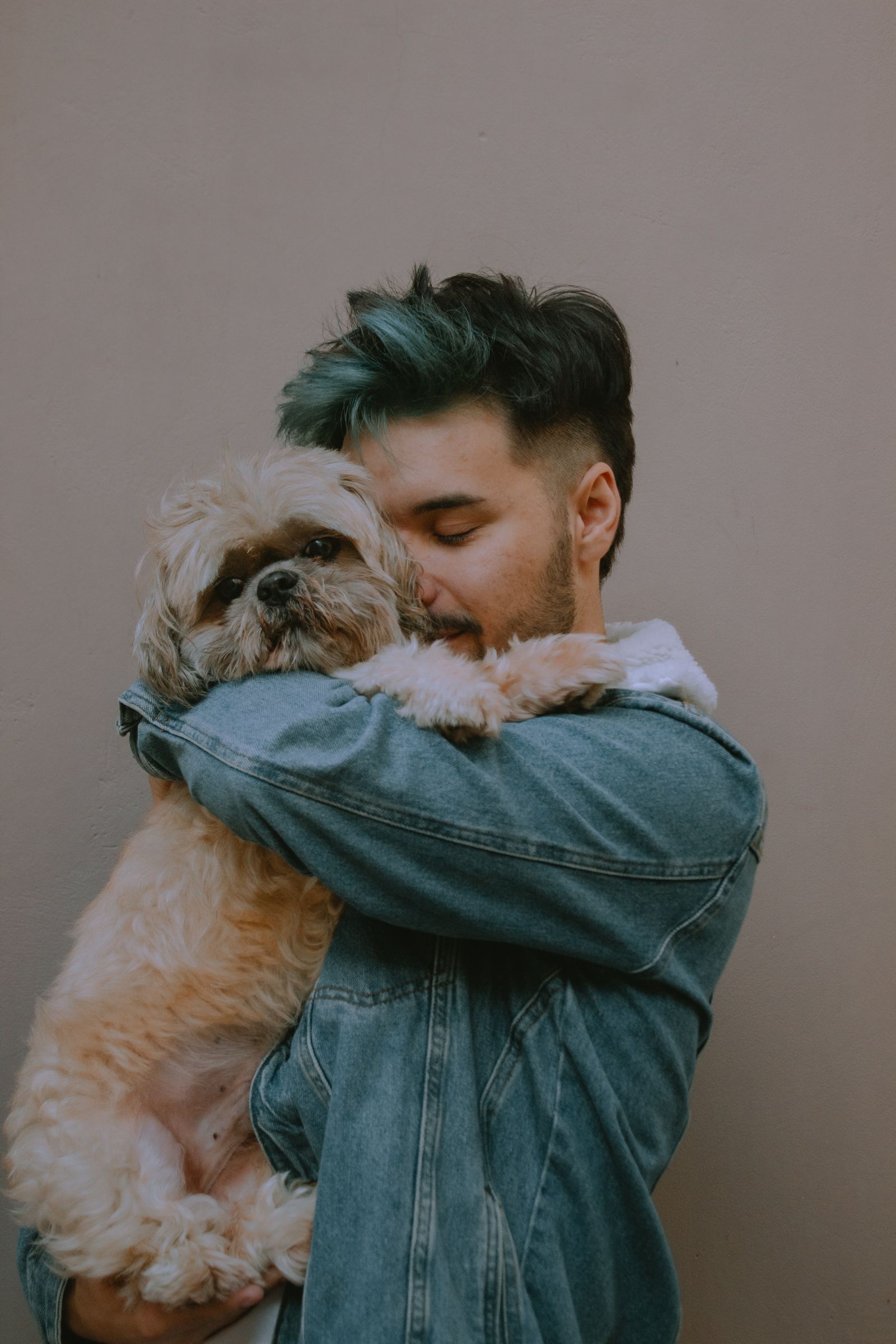 Un hombre abraza a su perro pequeño